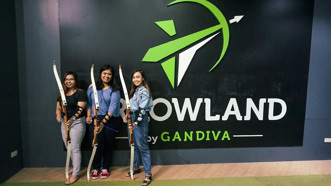 Group of friends posing with bows in front of Arrowland by Gandiva wall mural